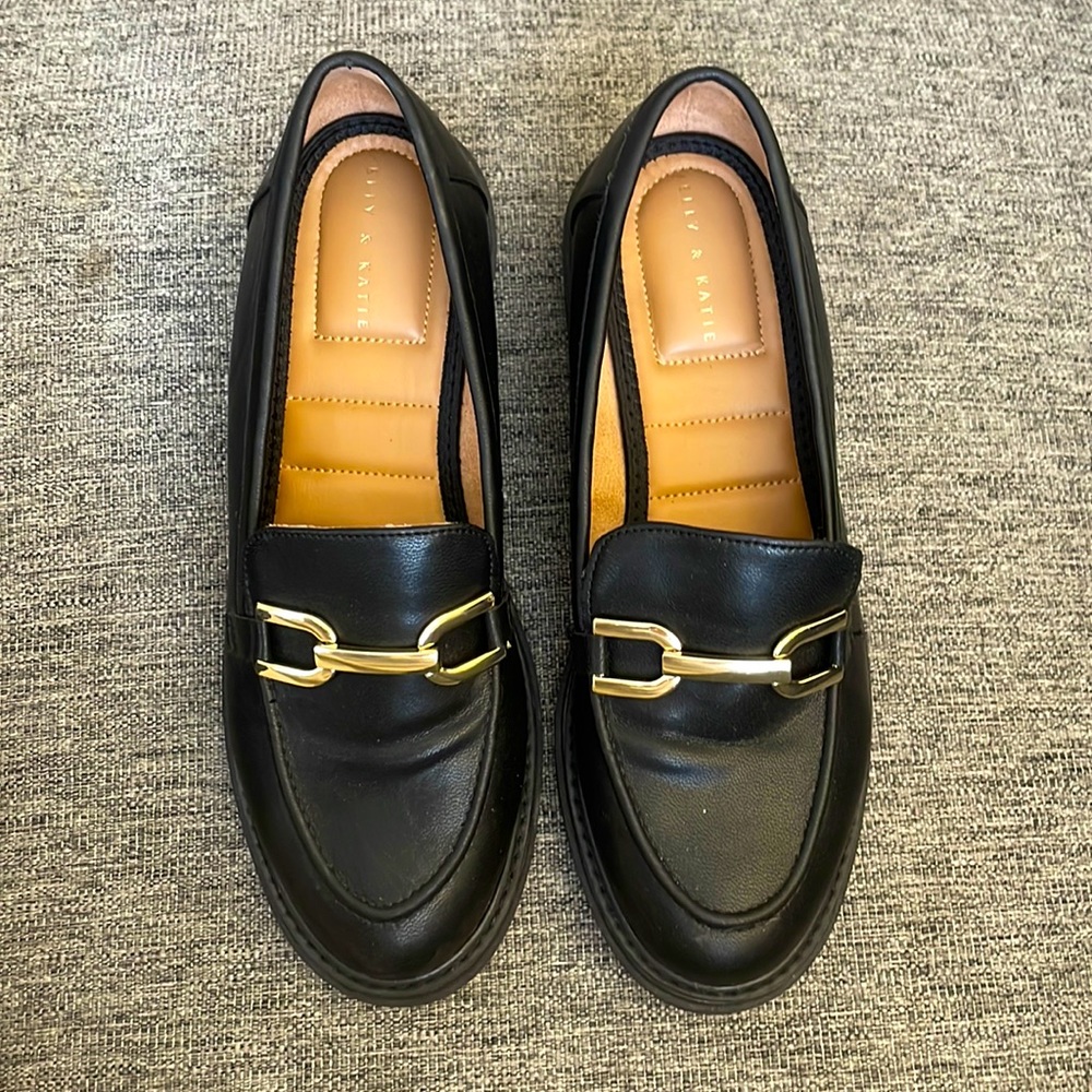 Black loafers with gold buckle